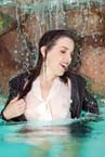 brunette fully clothed in the pool, under waterfall